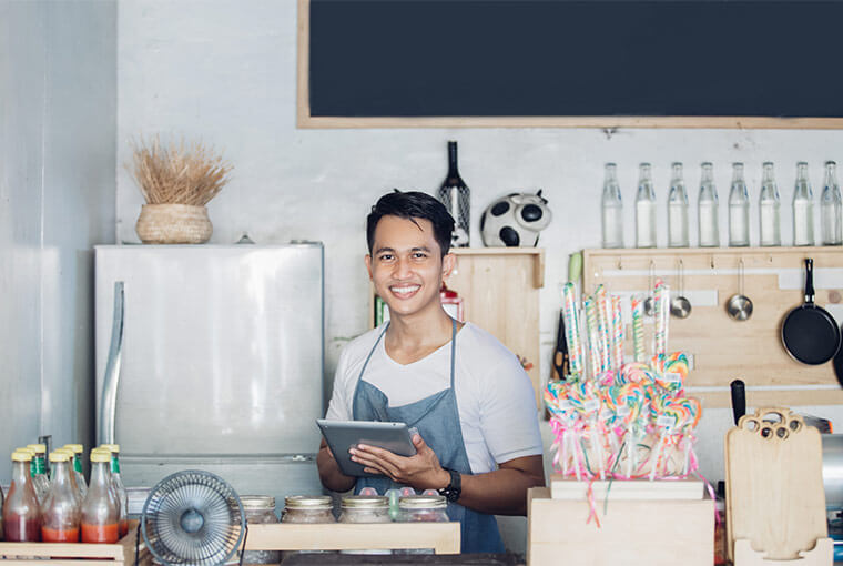 portrait of small business owner at his coffee shop using tablet pc