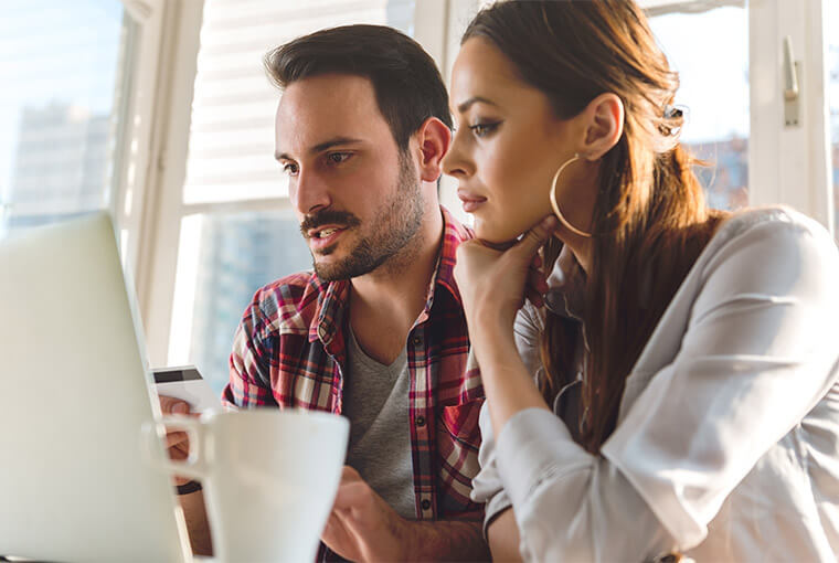 Young couple signing into their checking account on a laptop.
