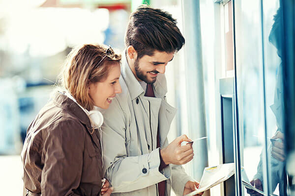 A man and a woman using an atm