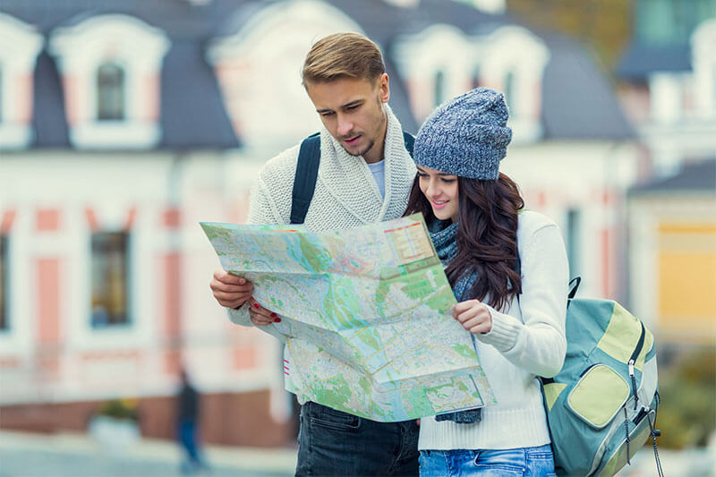 Young couple traveling with maps in hand in the city.