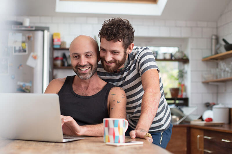 Couple using laptop in the kitchen