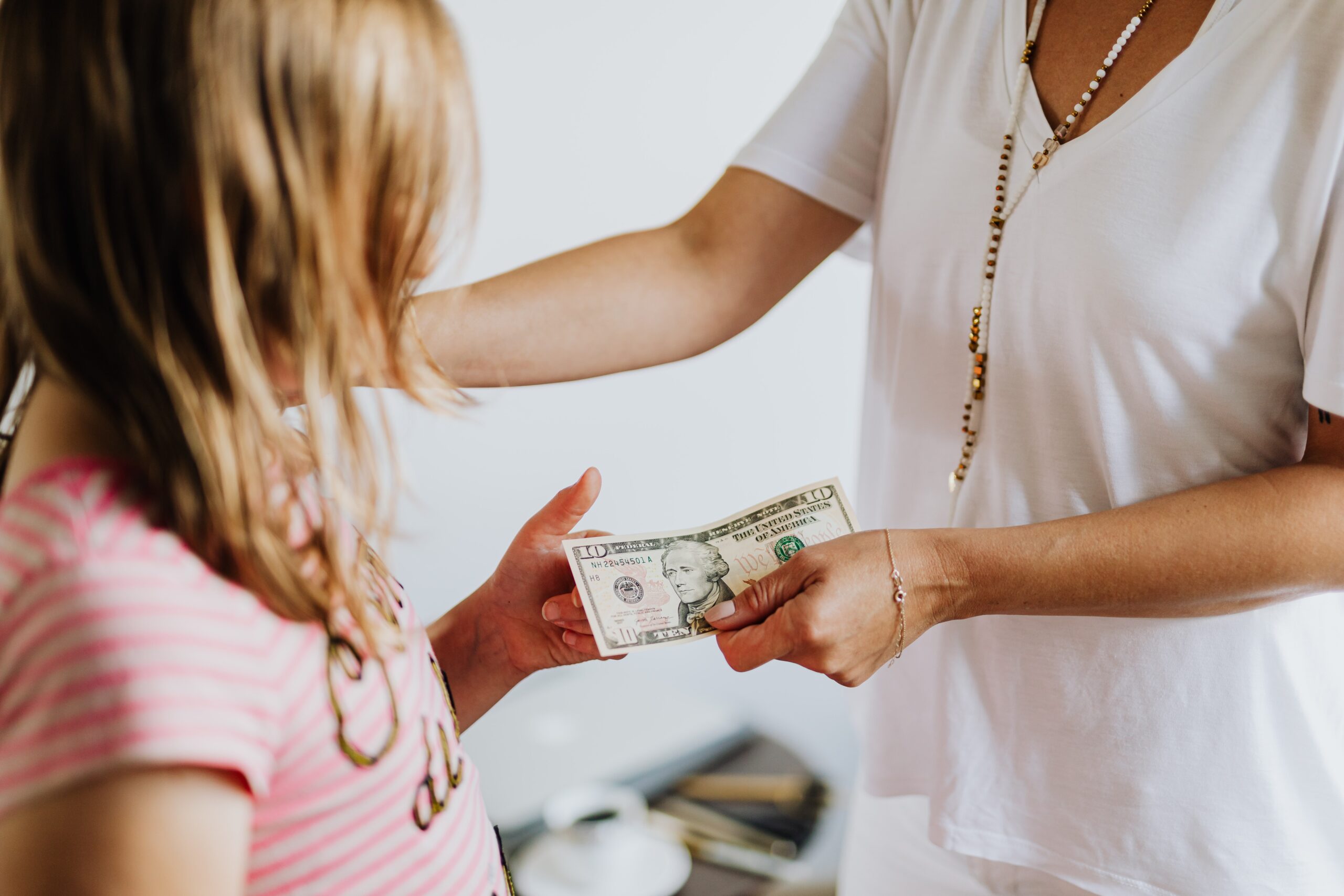 A mother hands her daughter money