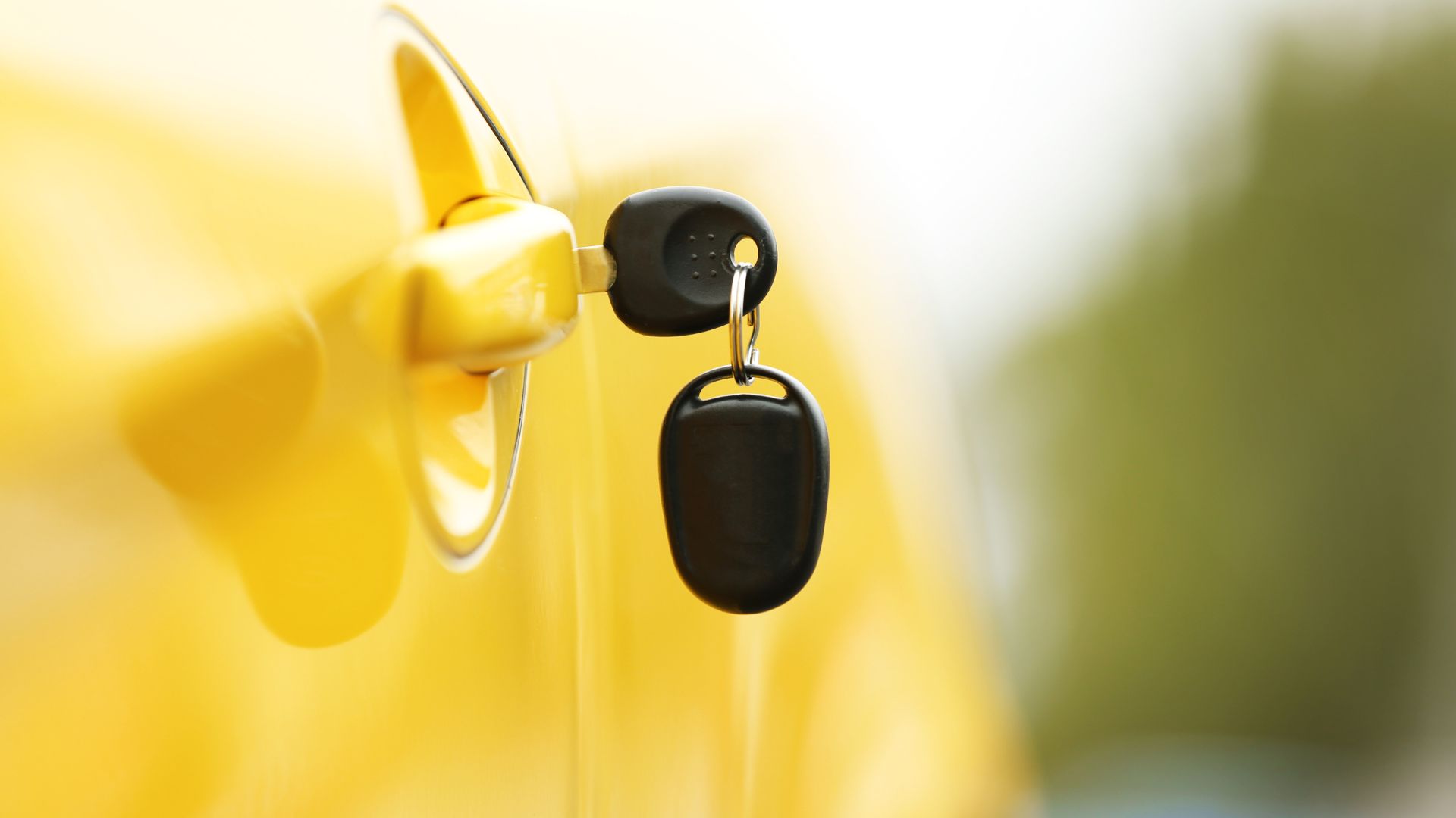keys dangle from a yellow car door