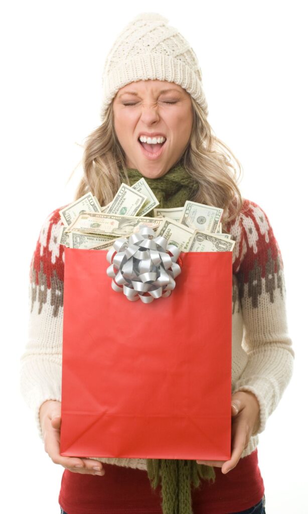 a woman holds a gift bag full of cash